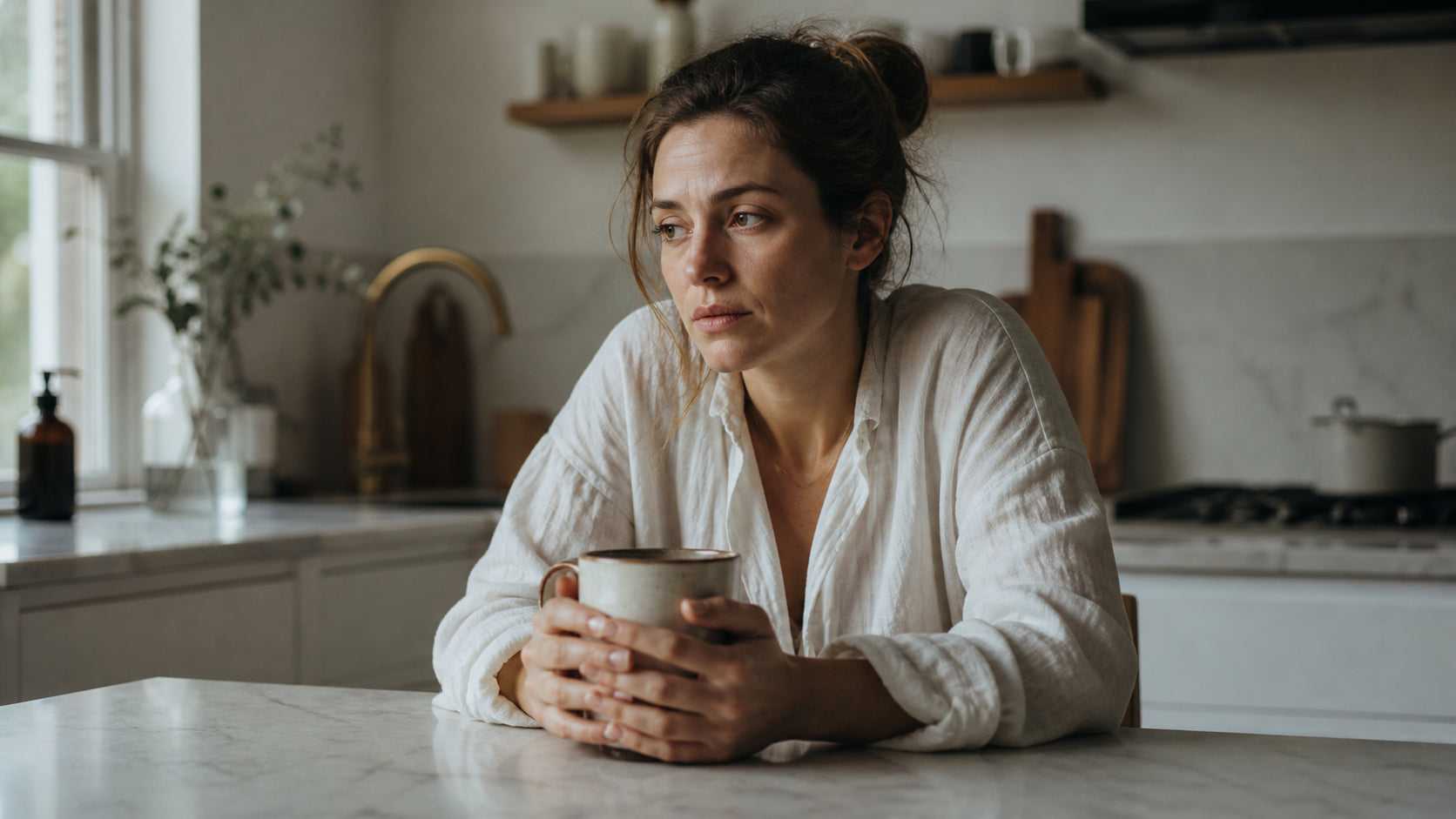 Woman experiencing digestive discomfort, holding a coffee mug